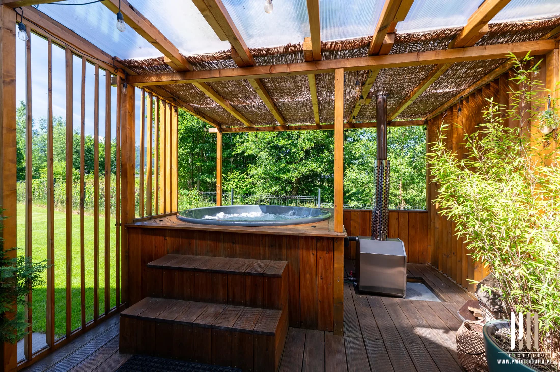 Balia z jacuzzi przy drewnianej saunie wśród ośnieżonych świerków